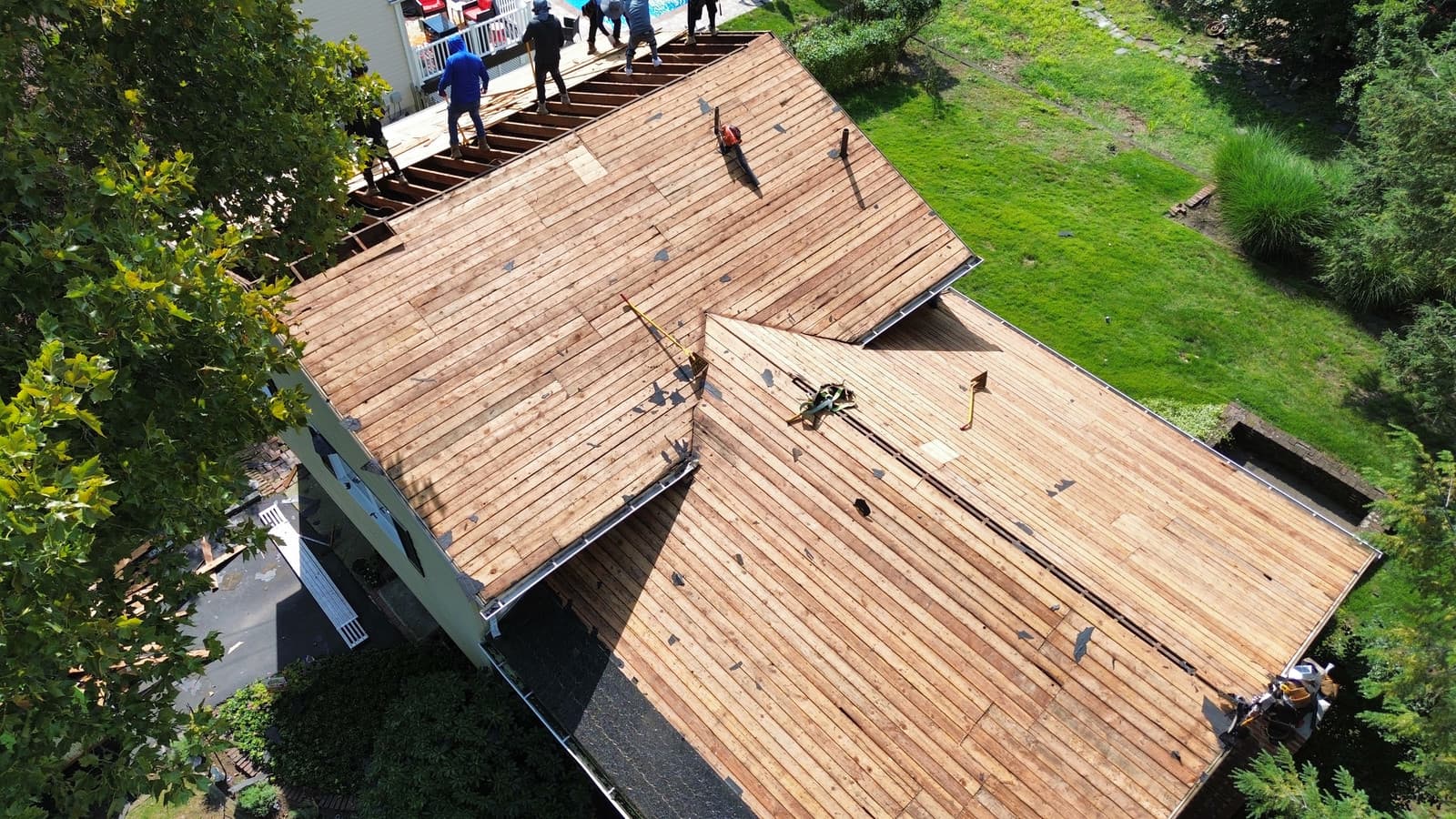 Full roof tear-off exposing the original wood plank decking during a roof replacement in Teaneck, NJ