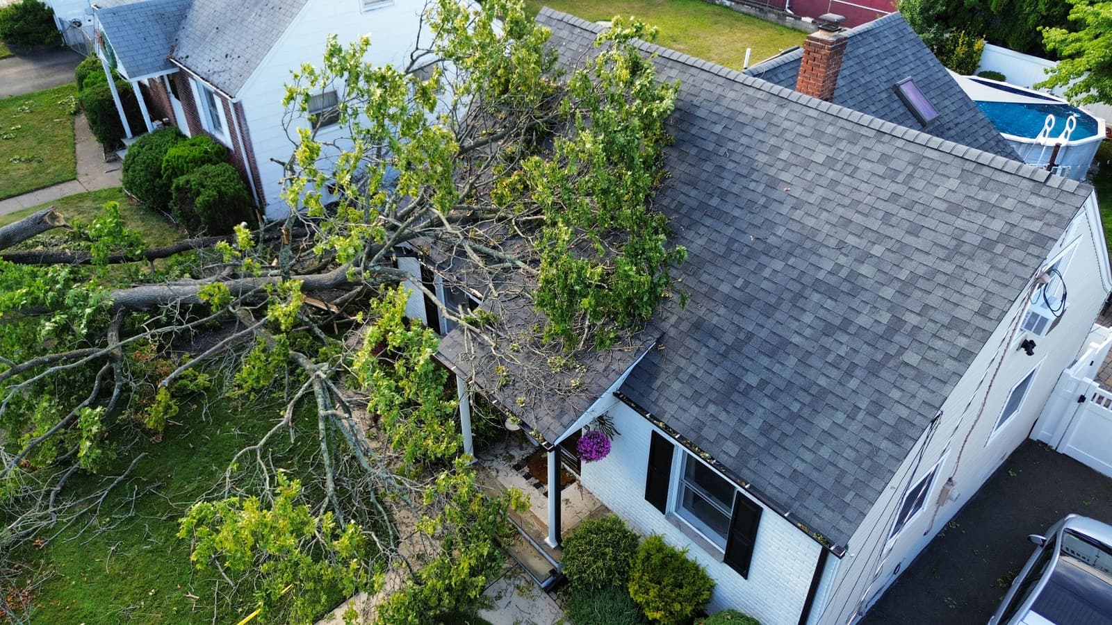 Fallen tree across the roof and front entry of a home in Wayne, NJ