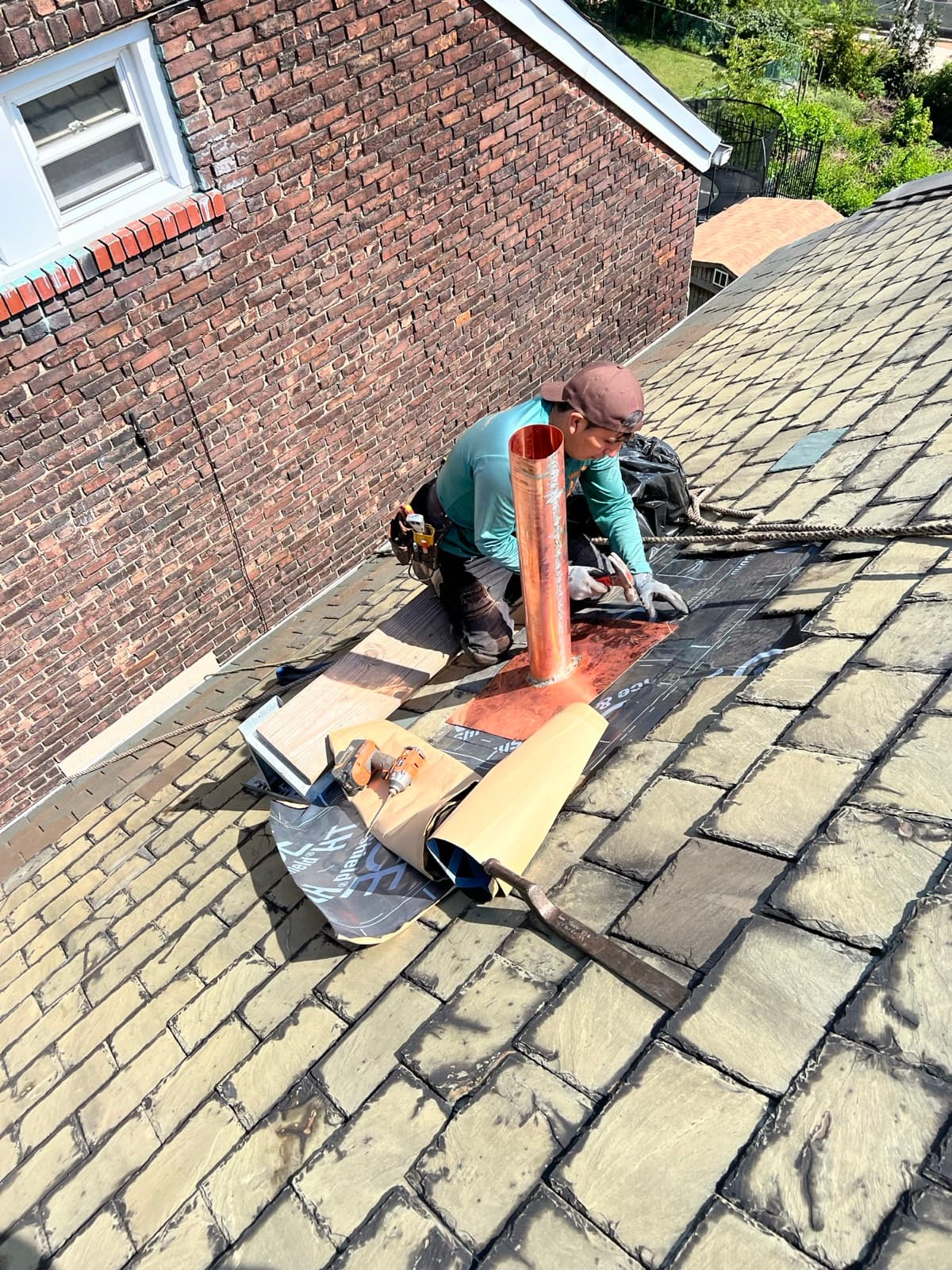 Zubar Roofing crew installing copper chimney flashing on a slate roof in New Jersey.