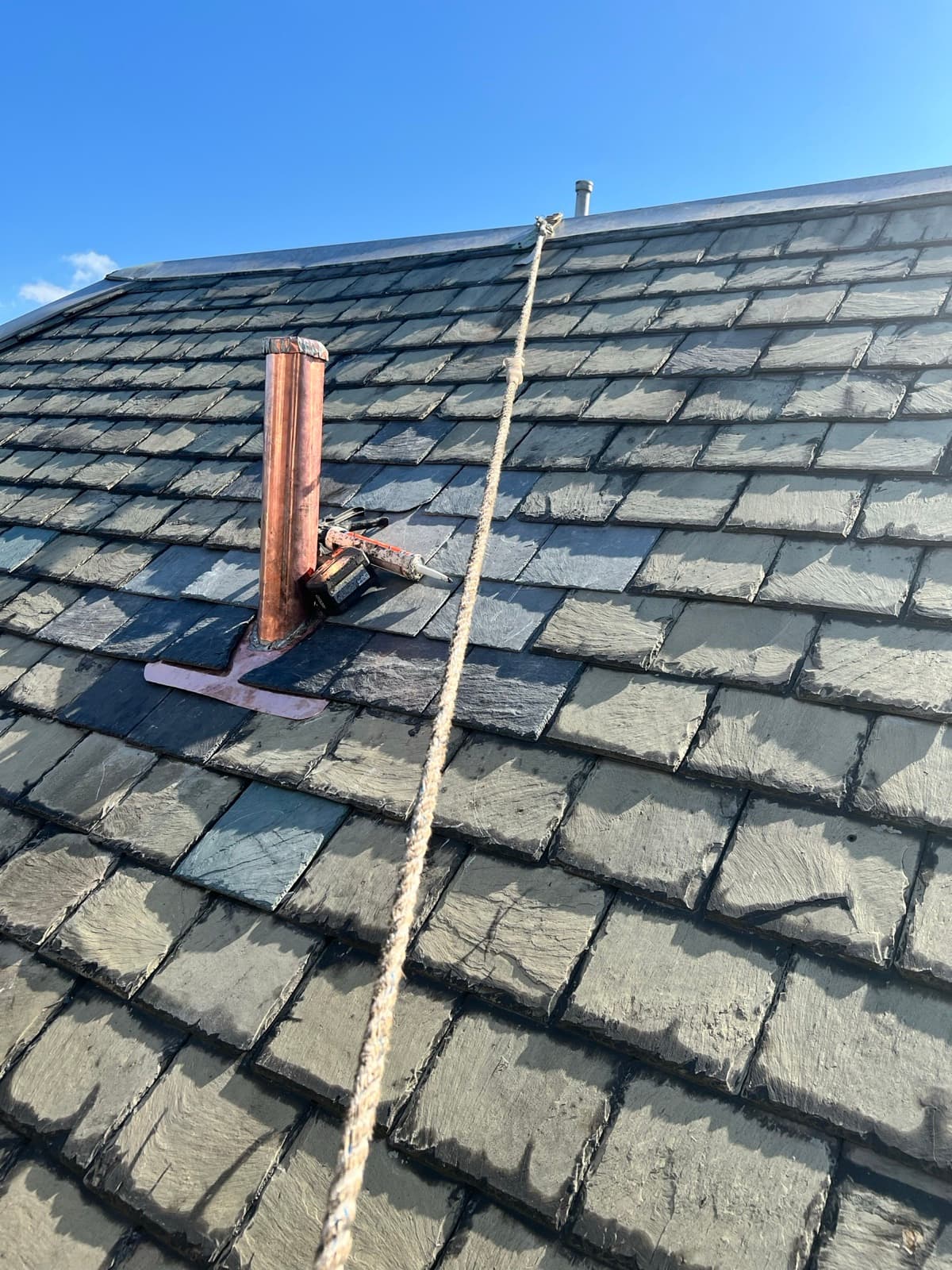 New copper step and counter-flashing let into a brick chimney on a slate roof — flashing repair by Zubar Roofing.