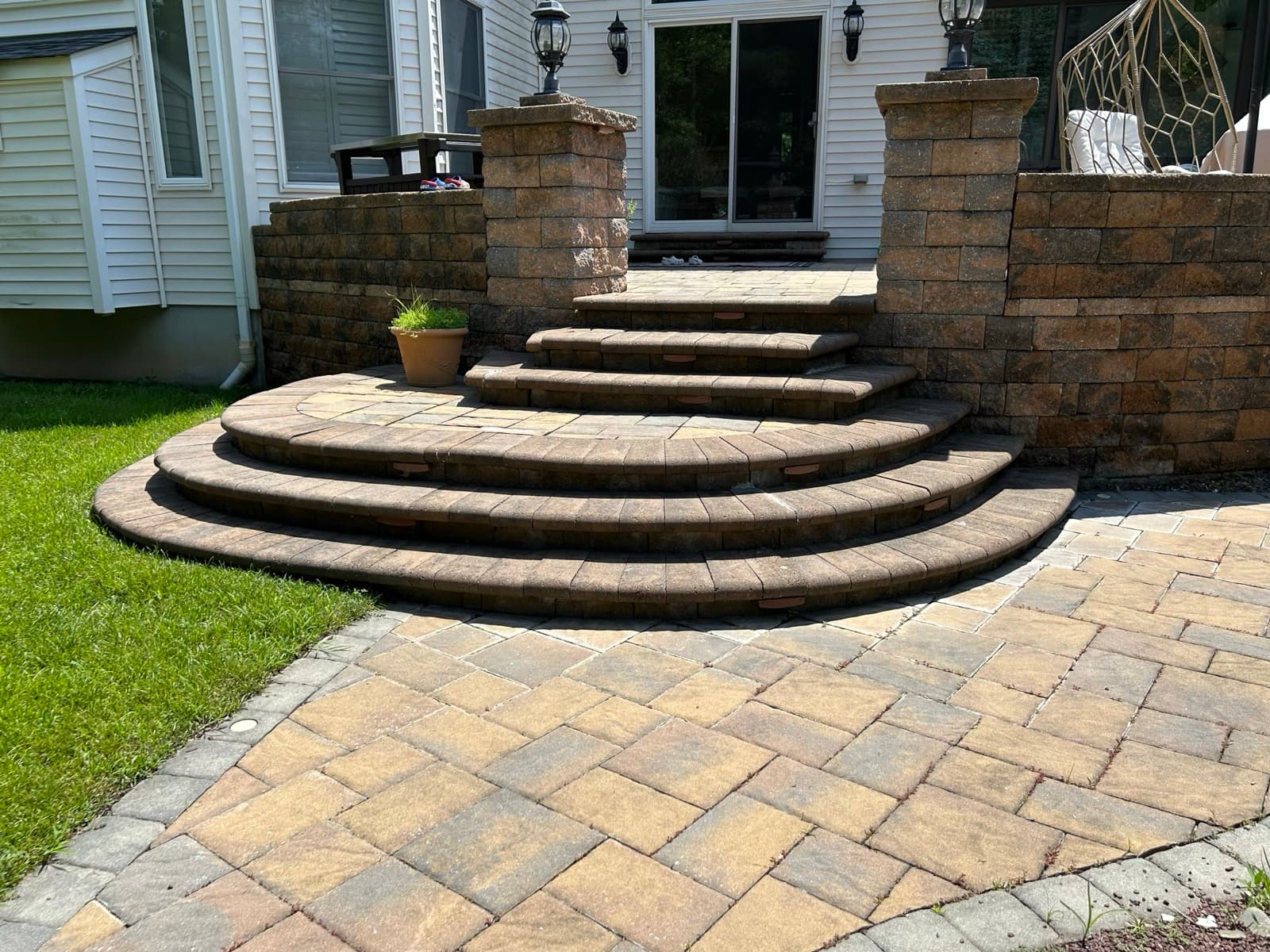 Paver stairs and a stone patio at a backyard entrance — exterior hardscaping by Zubar Roofing.