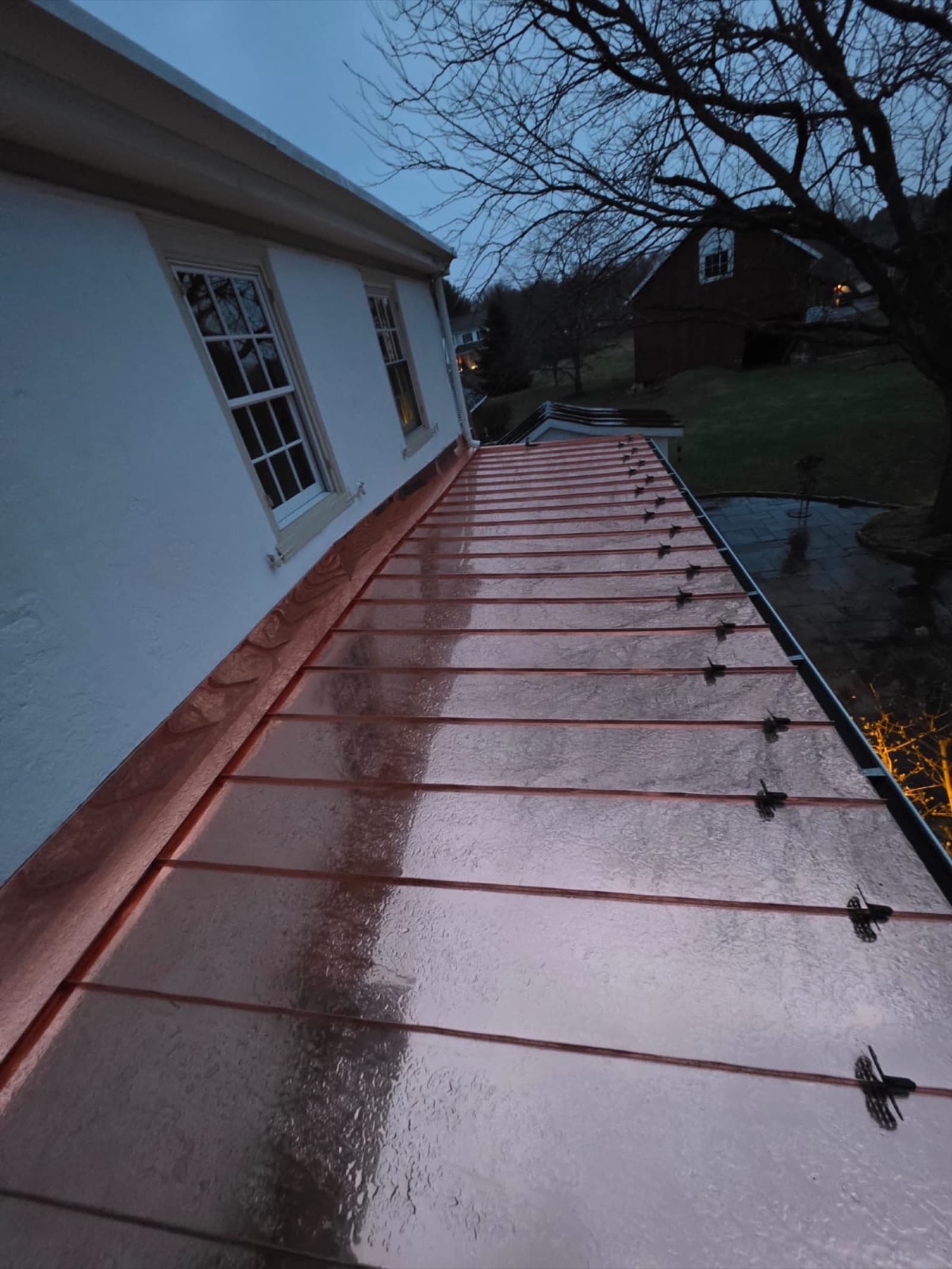 Seamless copper gutter detail along a standing-seam metal roof on a New Jersey home — installed by Zubar Roofing.